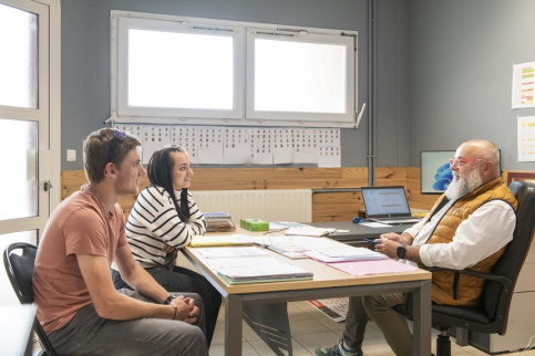 Deux élèves en train d'échanger avec le chef de service éducatif 