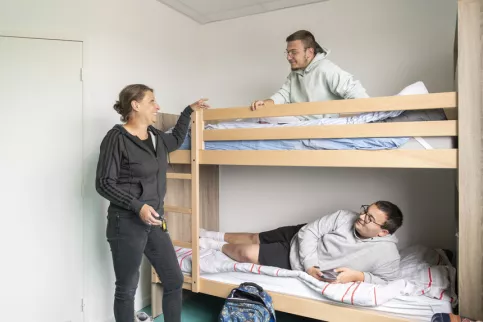 Deux jeunes et une éducatrice dans la chambre de l'internat du lycée Val de Drôme