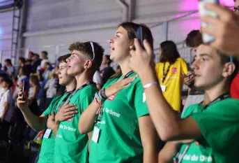 Des jeunes, mains sur la poitrine en train de chanter l'hymne national