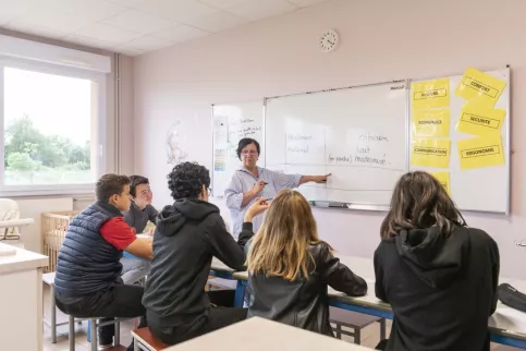 Cours dans une salle de classe avec un groupe d'élèves et leur professeure