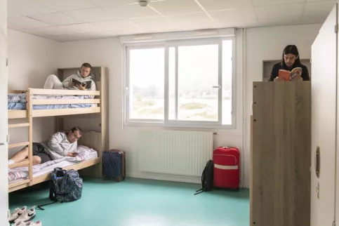 Trois jeunes en train de lire dans leur chambre de l'internat
