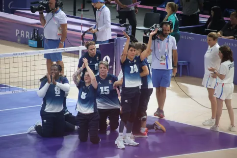 Equipe de France féminime de volley-ball assis en train de saluer le public du stade
