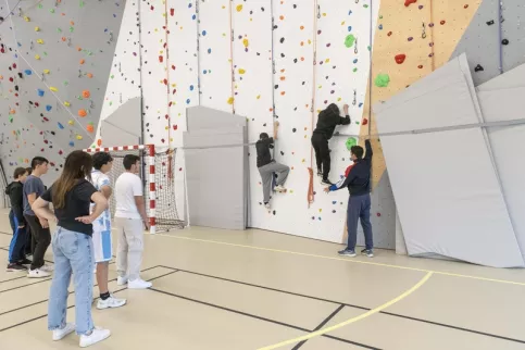 Elèves en cours d'escalade sur le mur du gynase