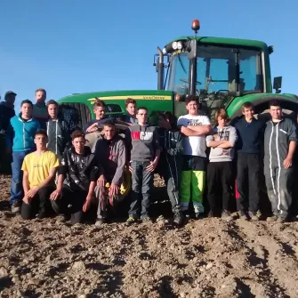 Des élèves du Lycée professionnel agricole Val de Drôme posent dans un champ devant un tracteur